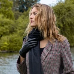 Women’s Touchscreen Three-Point Cashmere-Lined Leather Gloves -Dents woman wearing black cashmere lined leather gloves